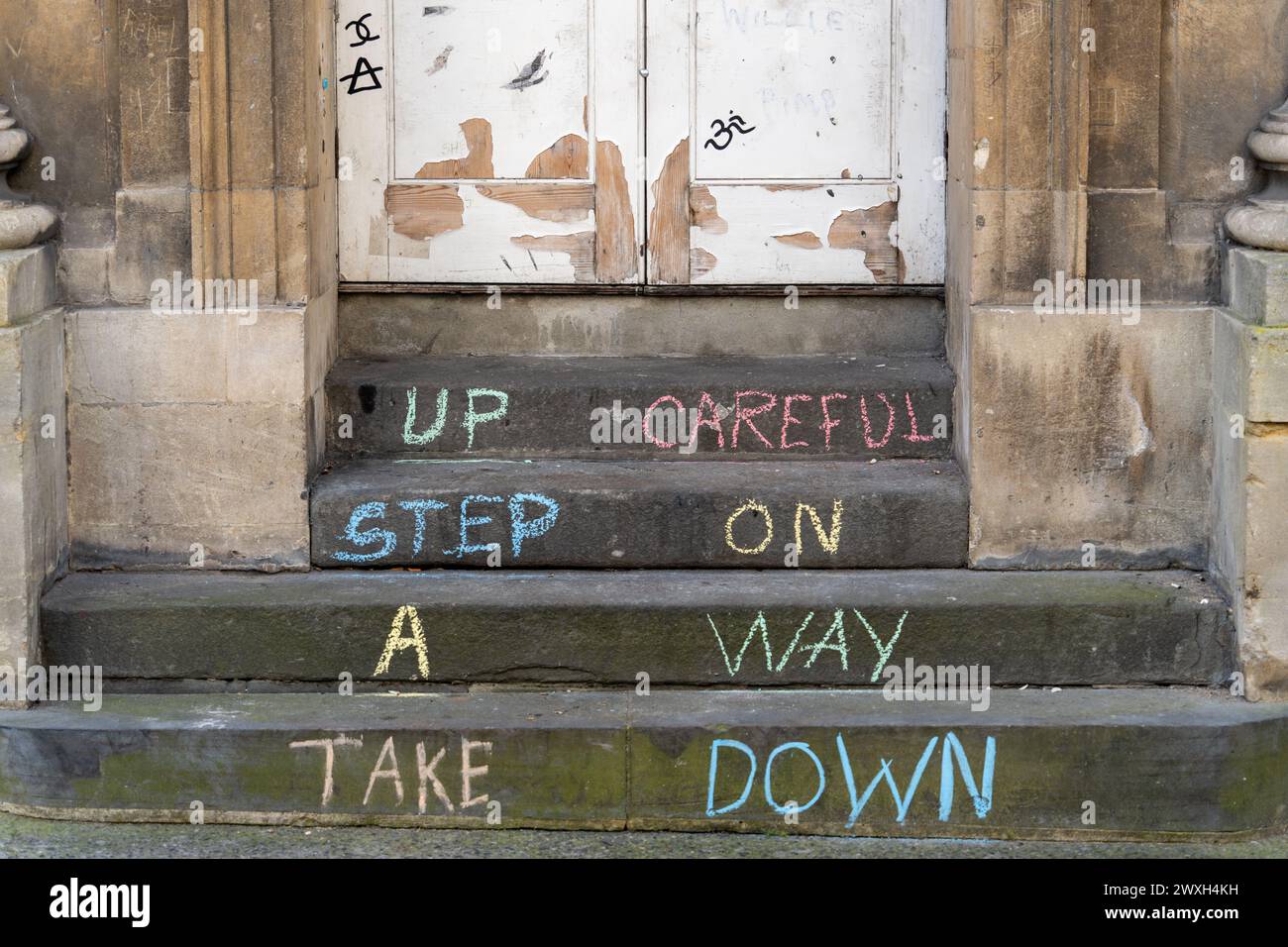 Chalk wording on steps. Concept of walking up and down steps, taking care on stairs, being careful, caution, health and safety, occupational therapy Stock Photo
