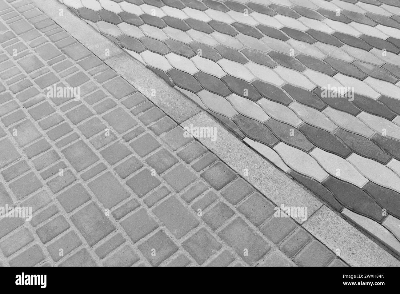 Two Kinds Paving Tiles Dividing Border Curb Mosaic Stone Street Road City Texture Background. Stock Photo
