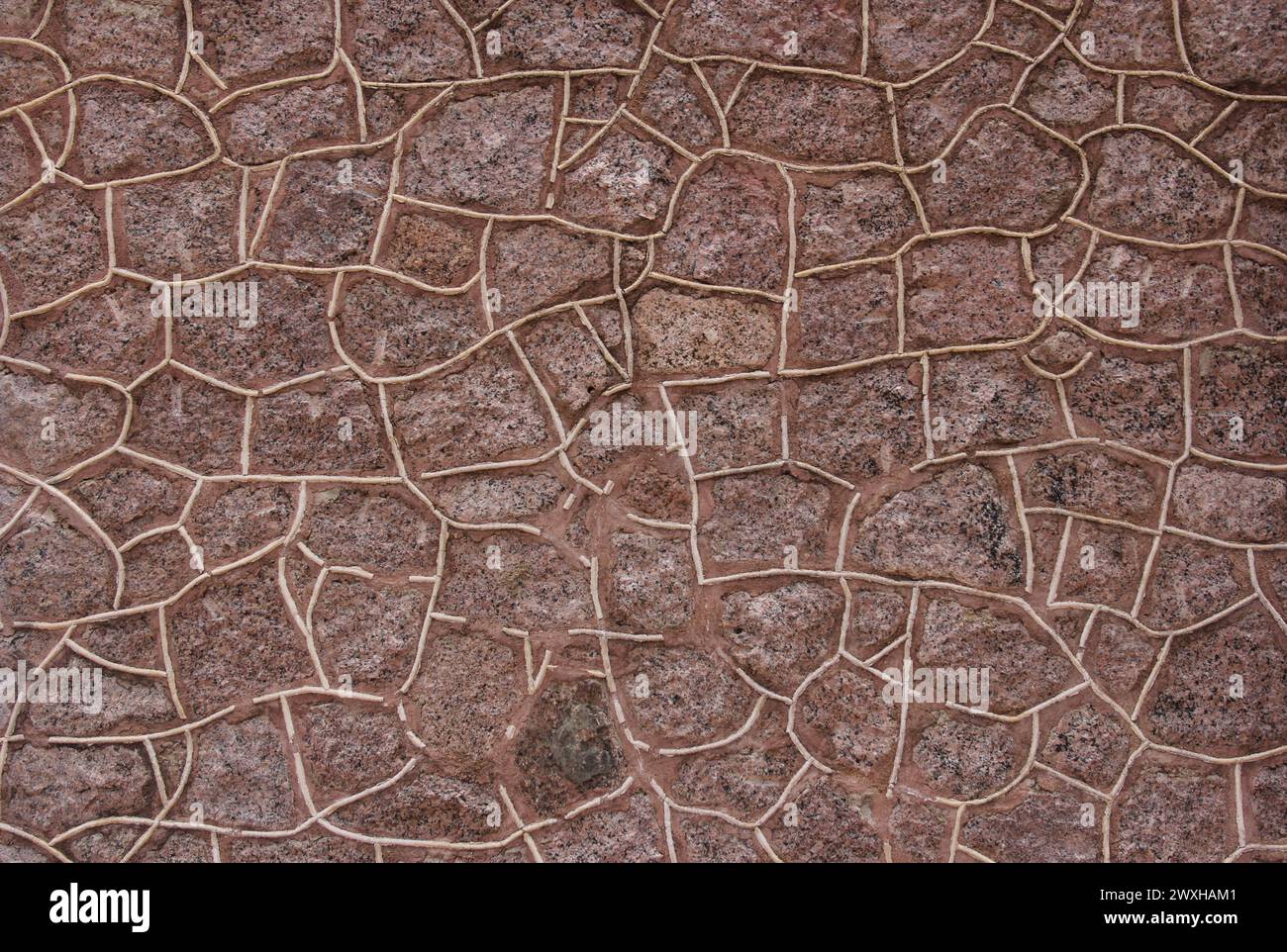 Stone wall texture with rough and chipped cracks, reminiscent of old Indian architecture Stock Photo