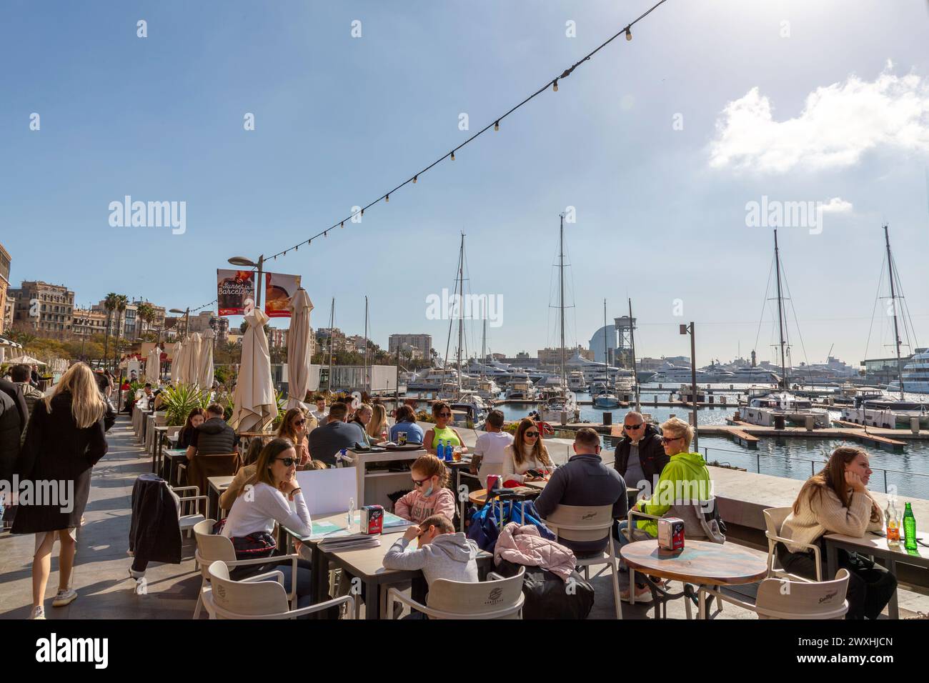 Barcelona, Spain - FEB 10, 2022: People sitting at a restaurant at the Marina Port Vell, located on the Mediterranean Coast of Barcelona, Catalonia, S Stock Photo