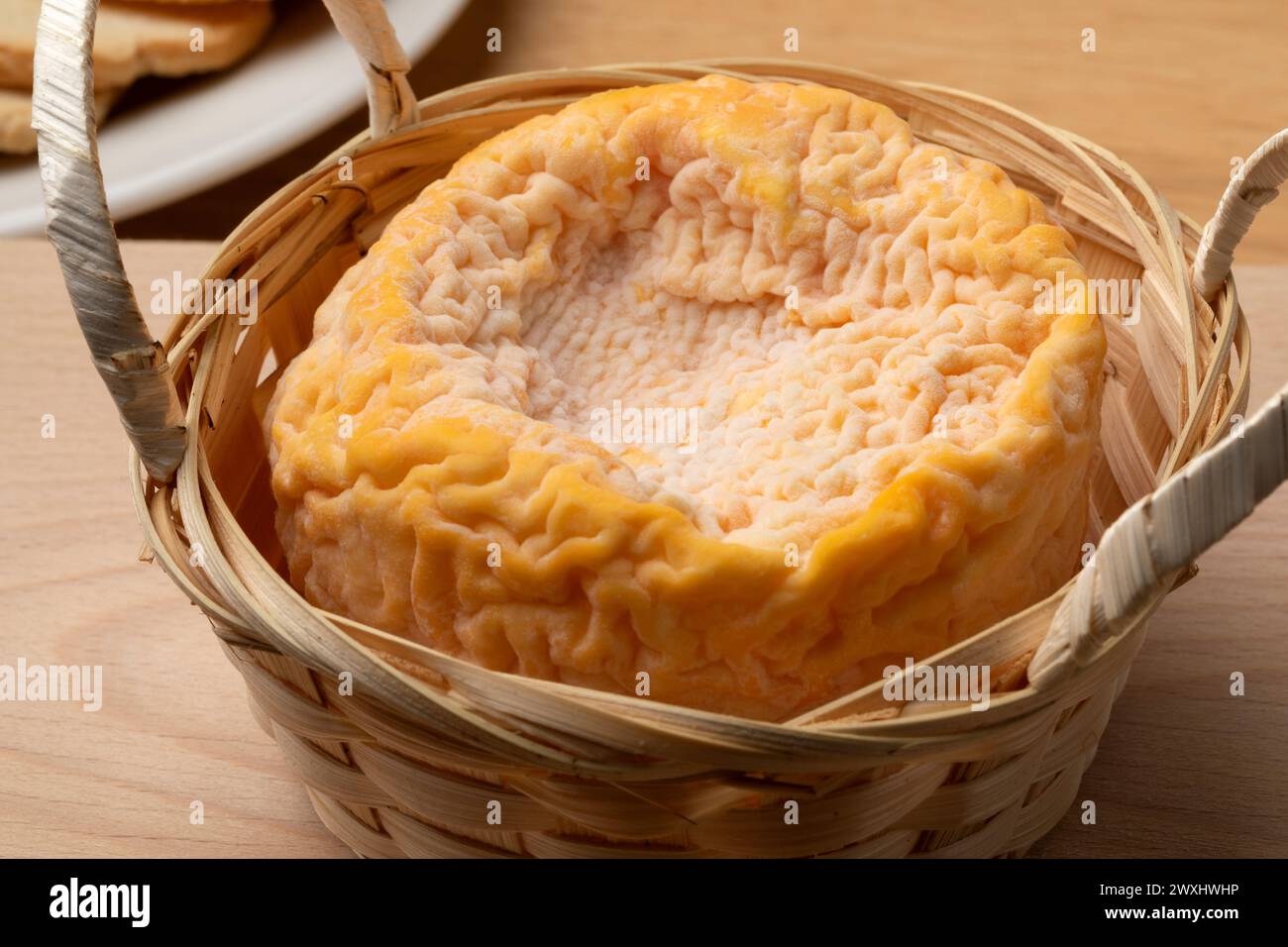 French Langres cheese refined with champagne in a basket close up Stock Photo
