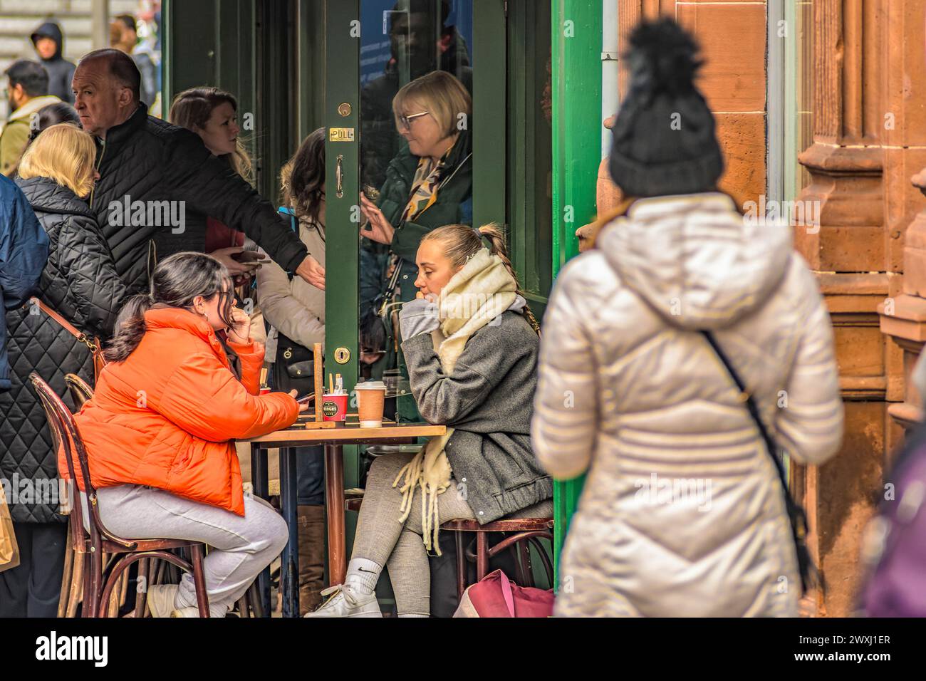 Women sitting in street café surrounded by crowd. Dublin. Ireland. Stock Photo