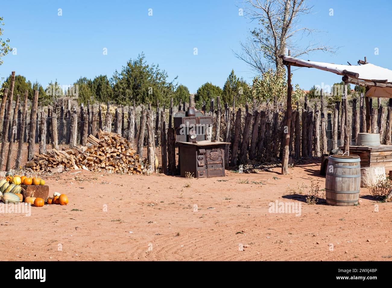 An old rusty cook stove and a stack of wood are featured in a display of nineteenth century living at Pipe Springs National Monument in Arizona. Stock Photo