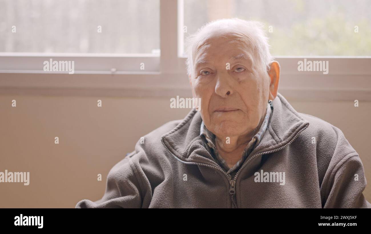 Aged man looking serious sitting on a geriatric Stock Photo