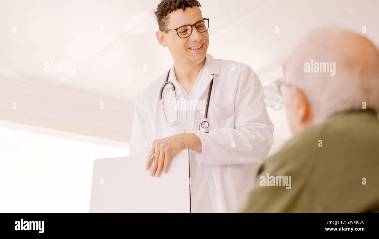 Doctor smiling kindly at an older man Stock Photo
