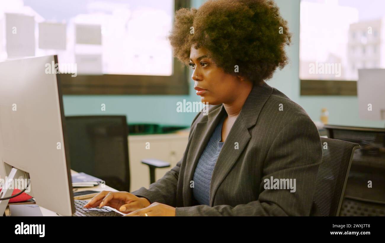Concentrated woman working using computer in a coworking Stock Photo