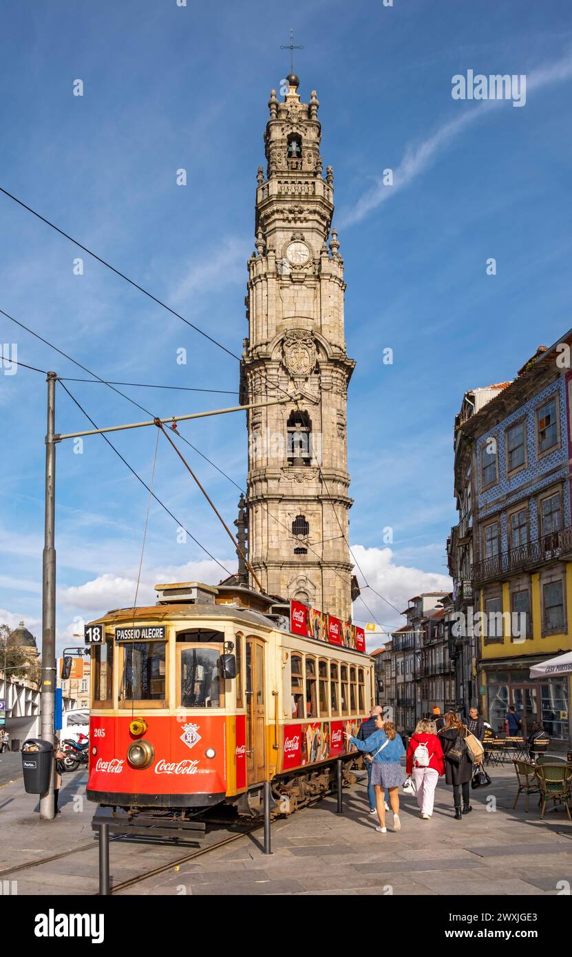 The iconic red tram number 18 pauses in front of the Clerigos Church Tower, Porto, Portugal Stock Photo