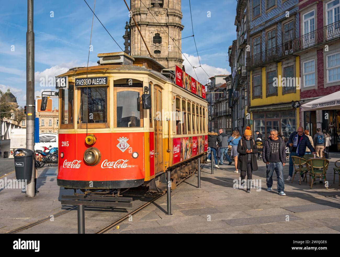 The iconic red tram number 18 pauses in front of the Clerigos Church Tower, Porto, Portugal Stock Photo