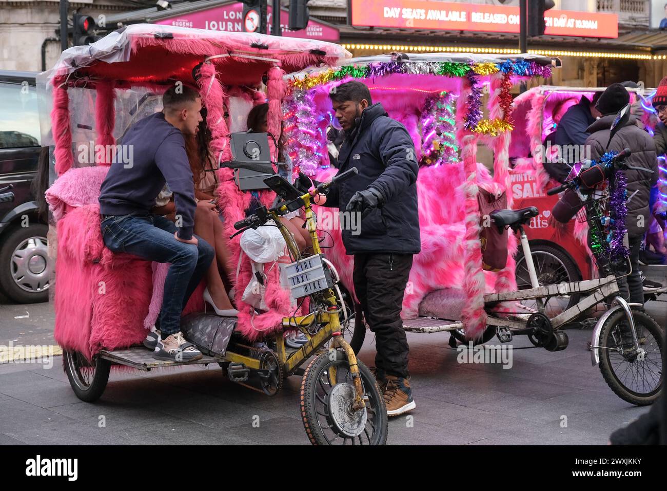 London, UK, 31st March, 2024. Colourful rickshaws wait for customers