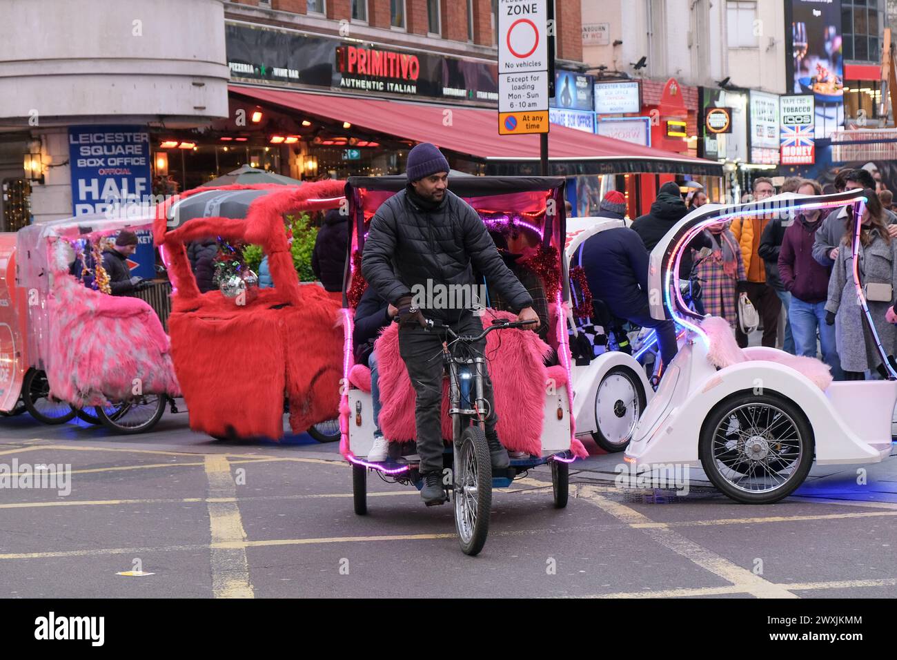 London, UK, 31st March, 2024. Colourful rickshaws wait for customers