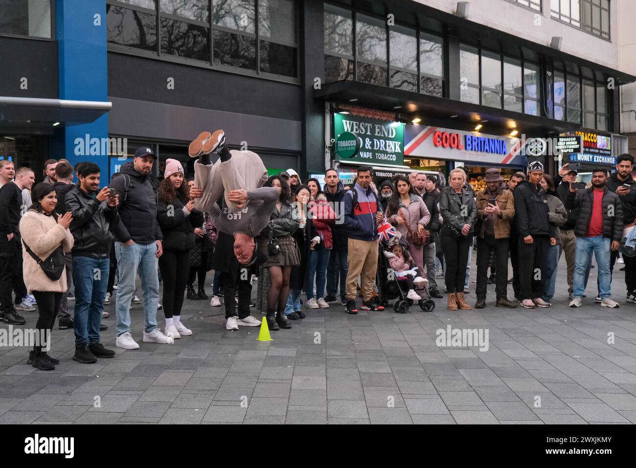 London, UK, 31st March, 2024. A crowd gathers to watch a street