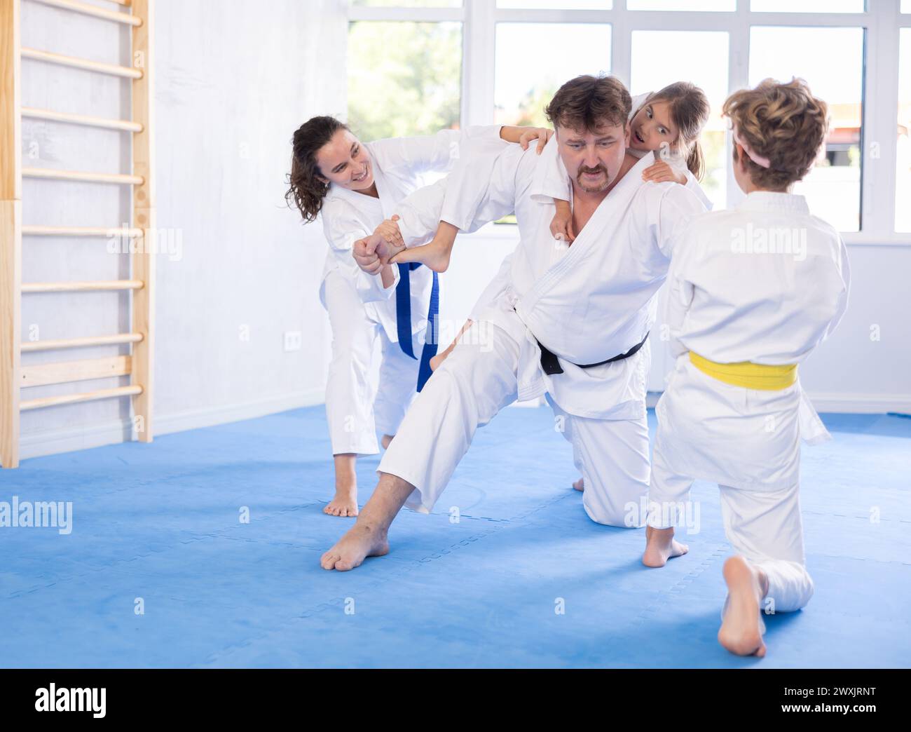 Judo or jiu jitsu classes family with two children practicing