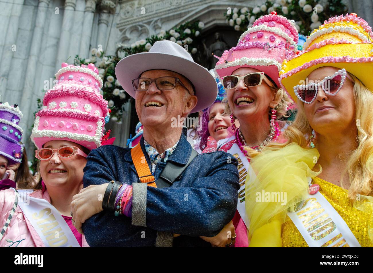 New York, USA. 31st Mar, 2024. A man poses for a picture with women wearing cake-shaped hats on the steps of St. Patrick's Cathedral in Manhattan, NY during the annual Easter Parade and Bonnet Festival on March 31, 2024. The parade and festival, which takes place on Easter Sunday, is a New York City tradition dating back to the 1870s. (Photo by Katie Smith/Sipa USA) Credit: Sipa USA/Alamy Live News Stock Photo
