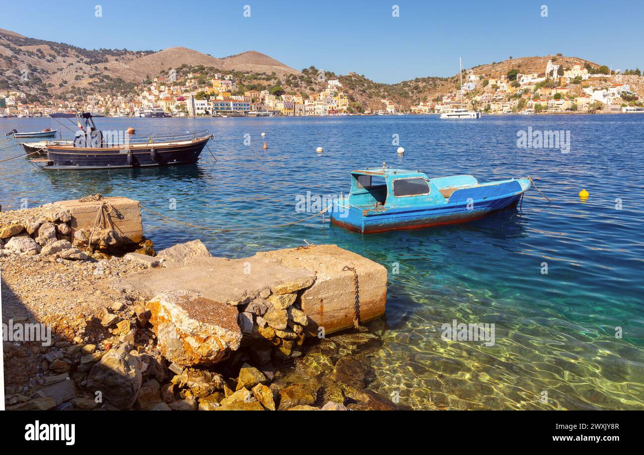 View of old traditional fishing boats in the harbor of Sumi village on a sunny day. Greece. Dodecanese. Stock Photo
