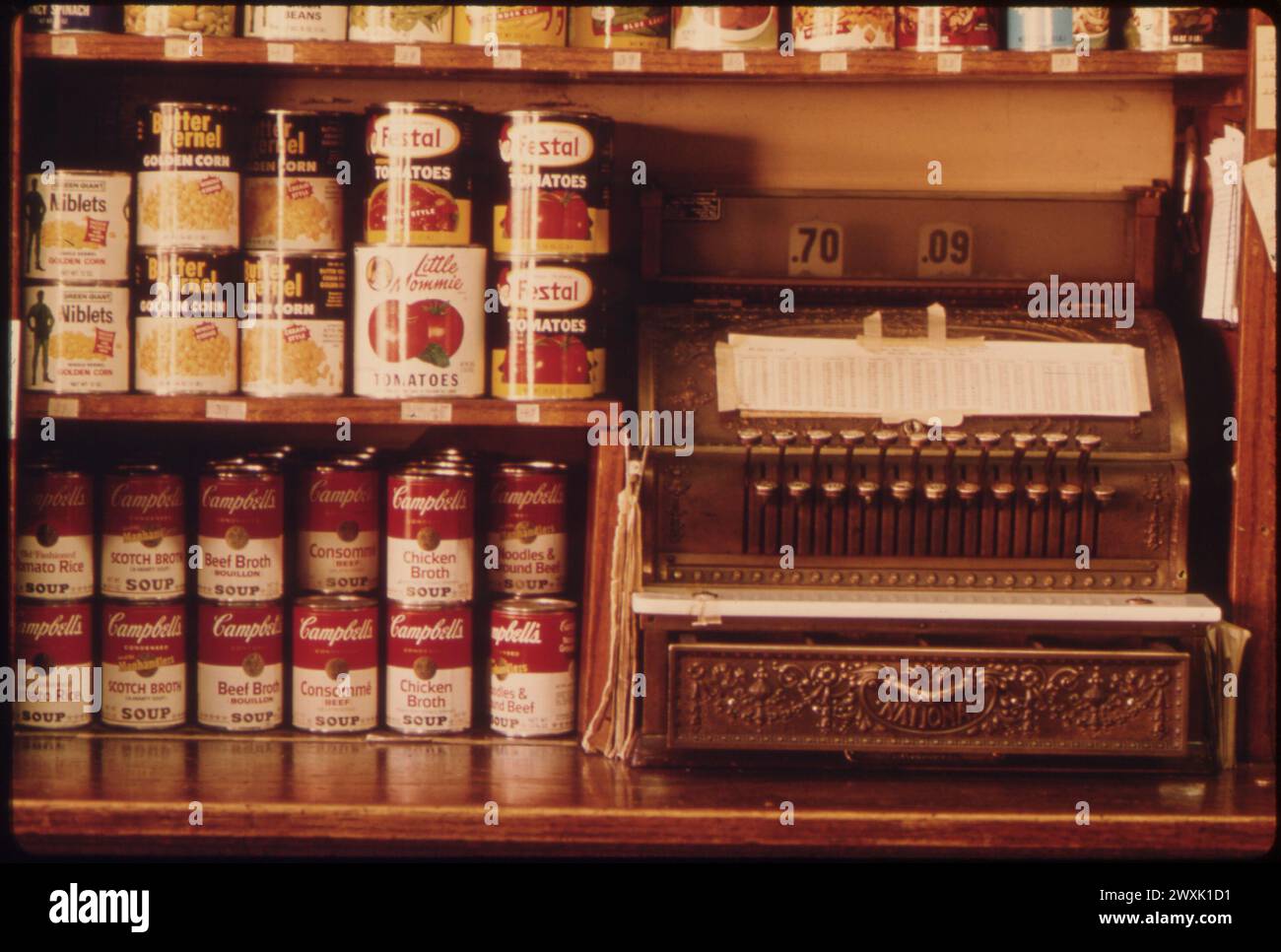 Vintage American Photograph 1970s.  Old Style Cash Register and Canned Goods in a Butcher Shop in New Ulm, Minnesota ..., October 1974 .  Source Series: DOCUMERICA: The Environmental Protection Agency's Program to Photographically Document Subjects of Environmental Concern, by Bruce  Bisping. Stock Photo