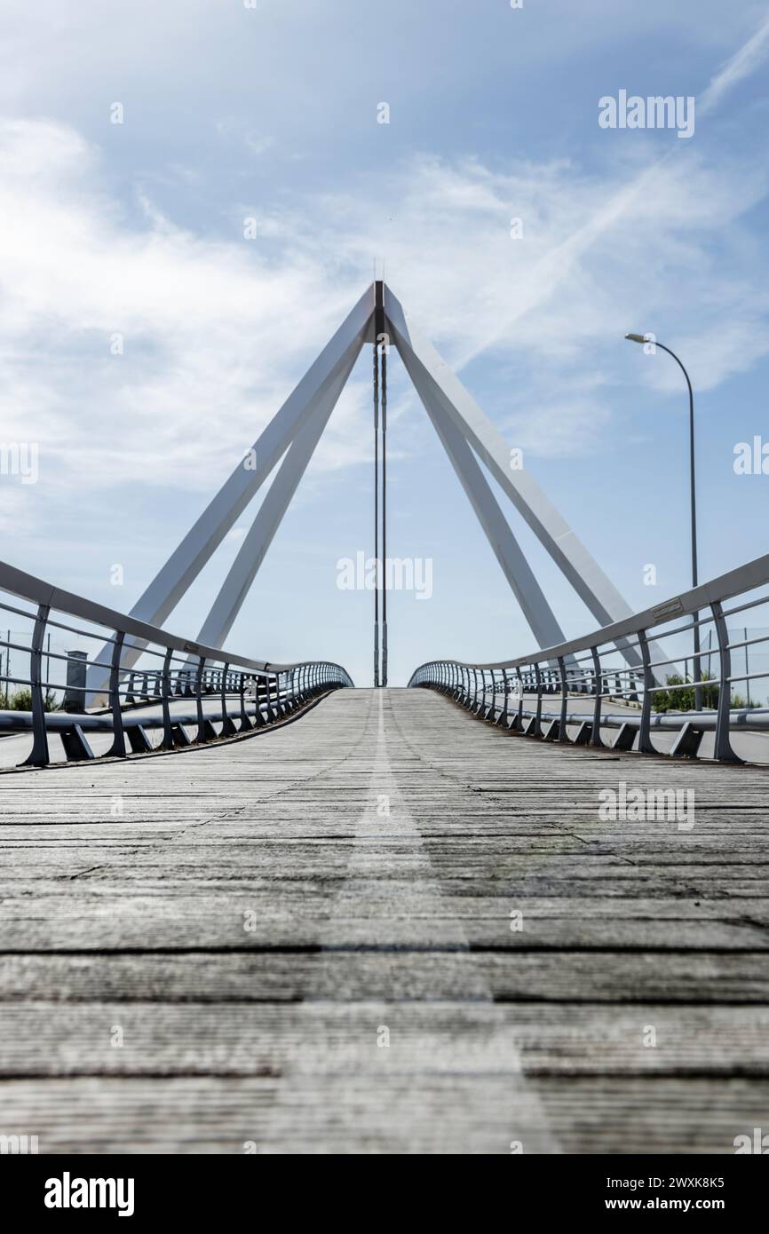 Metal structure of a small bridge with metal suspension structure, walkways and wooden floors for pedestrians Stock Photo