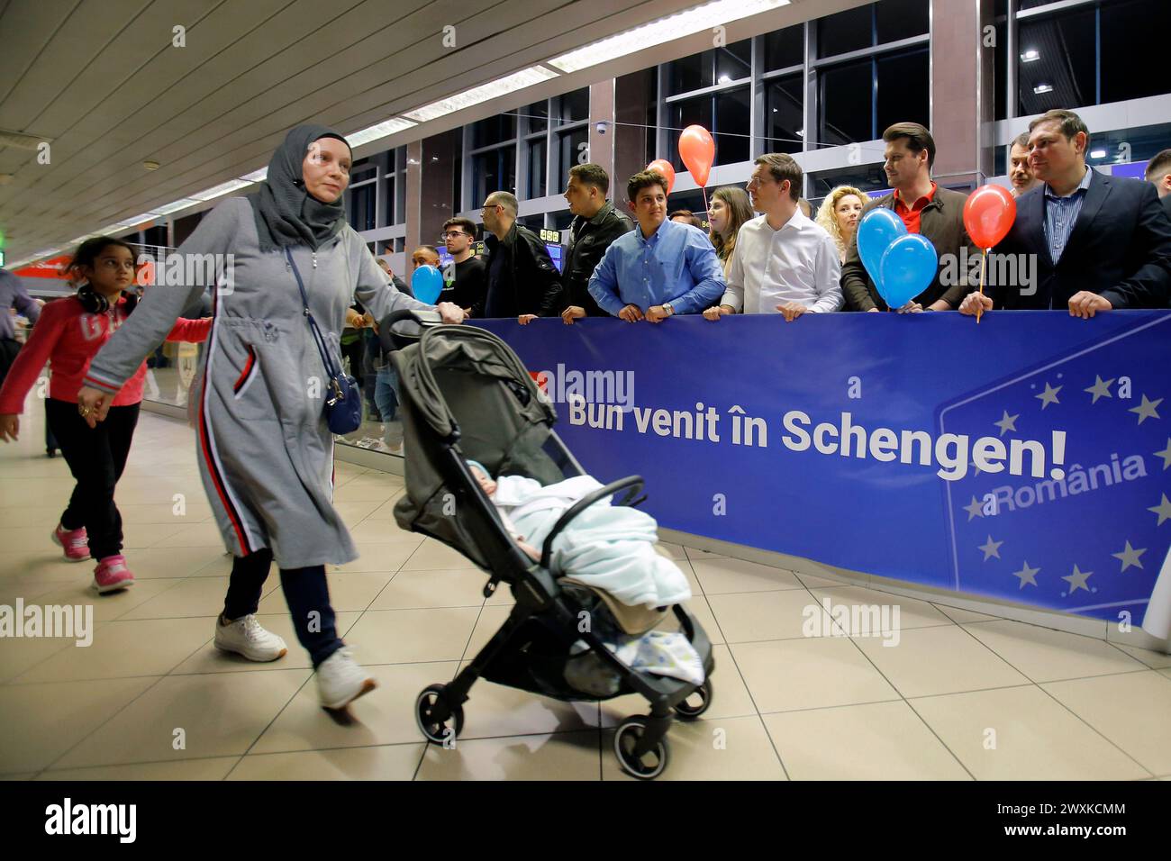 Beijing, Romania. 31st Mar, 2024. Travelers walk past a sign reading 'Welcome to Schengen' at Henri Coanda International Airport near Bucharest, Romania, March 31, 2024. Bulgaria along with its northern neighbor Romania partially joined the passport-free Schengen area on Sunday. 'On 31 March, Bulgaria and Romania become Schengen members: the Schengen rules will apply in both Member States including on issuing Schengen visas and controls at the internal air and sea borders will be lifted,' the European Commission (EC) said in a press release. Credit: Cristian Cristel/Xinhua/Alamy Live News Stock Photo