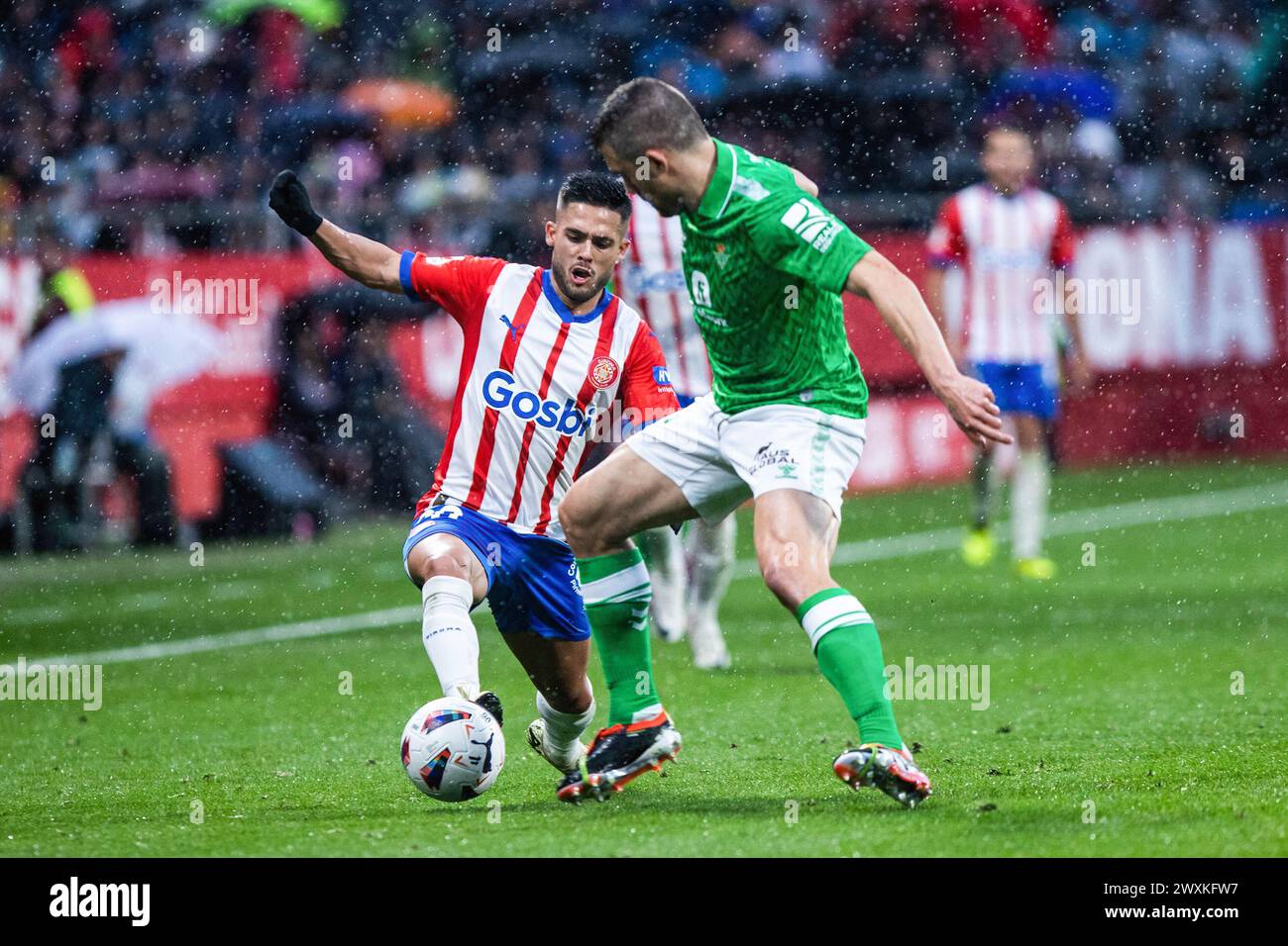 Madrid, Spain. 31st Mar, 2024. Yan Couto (L) of Girona F.C seen in action during the LaLiga EA Sports match between Girona F.C and Real Betis at Estadi Montilivi. Final score; Girona F.C 3:2 Real Betis Credit: SOPA Images Limited/Alamy Live News Stock Photo