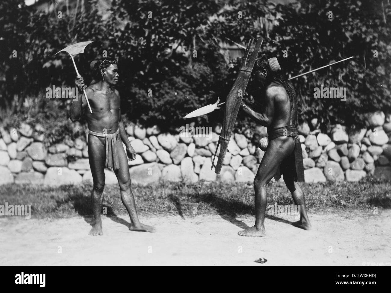 Original caption: Bontoc, Bontoc Province, The Philippines. Sept. 19, 1931. Two natives of Bontoc pose for the cameraman. Not many years ago these people were head-hunters and the Spear and Head-Axe were their chief weapons. Stock Photo