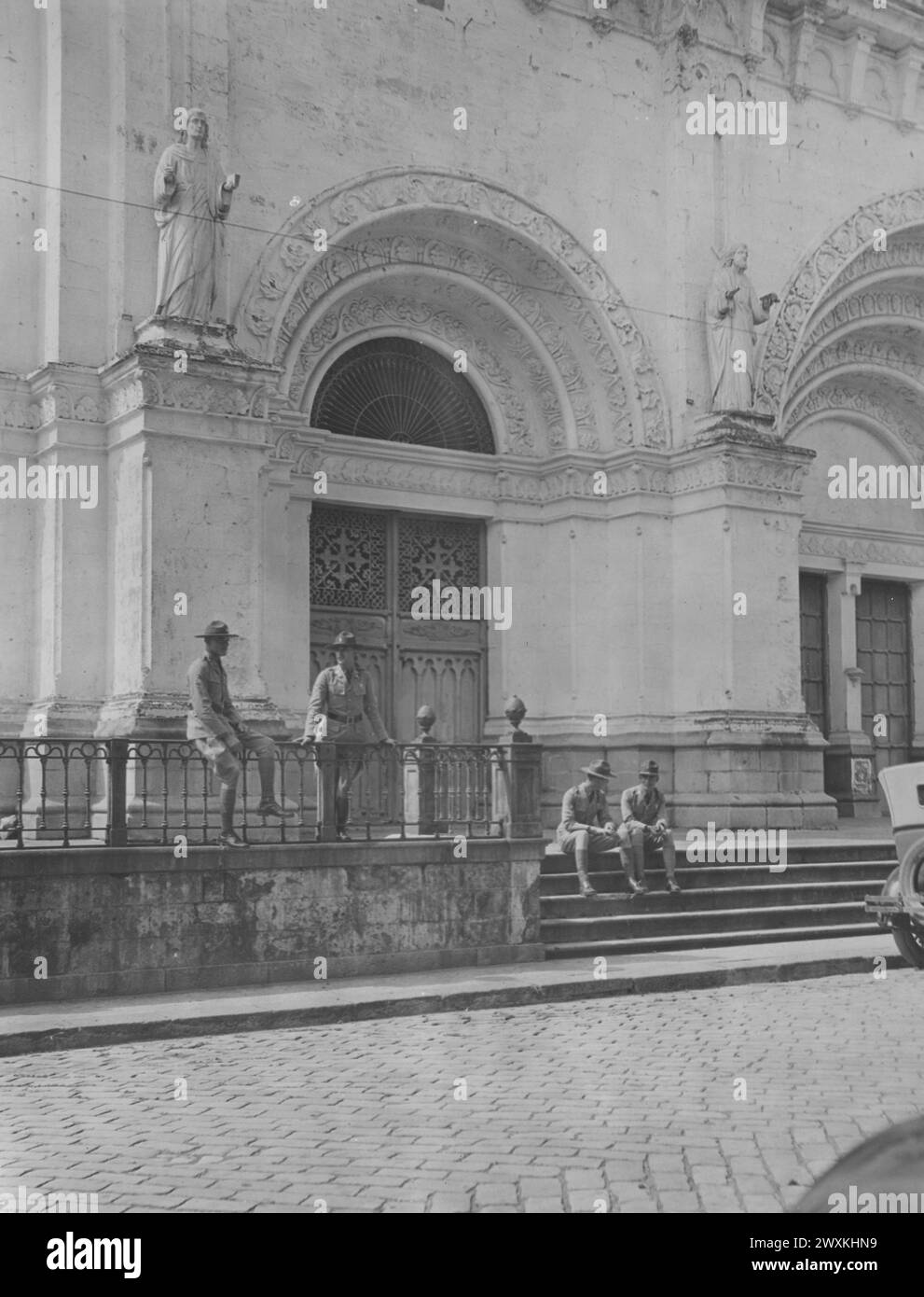 Soldiers standing in front of the Metropolitan Church of Manila, or 'The Cathedral of the Immaculate Conception.' Walled City, Manila, Philippine Islands ca. 1914-1919. Stock Photo