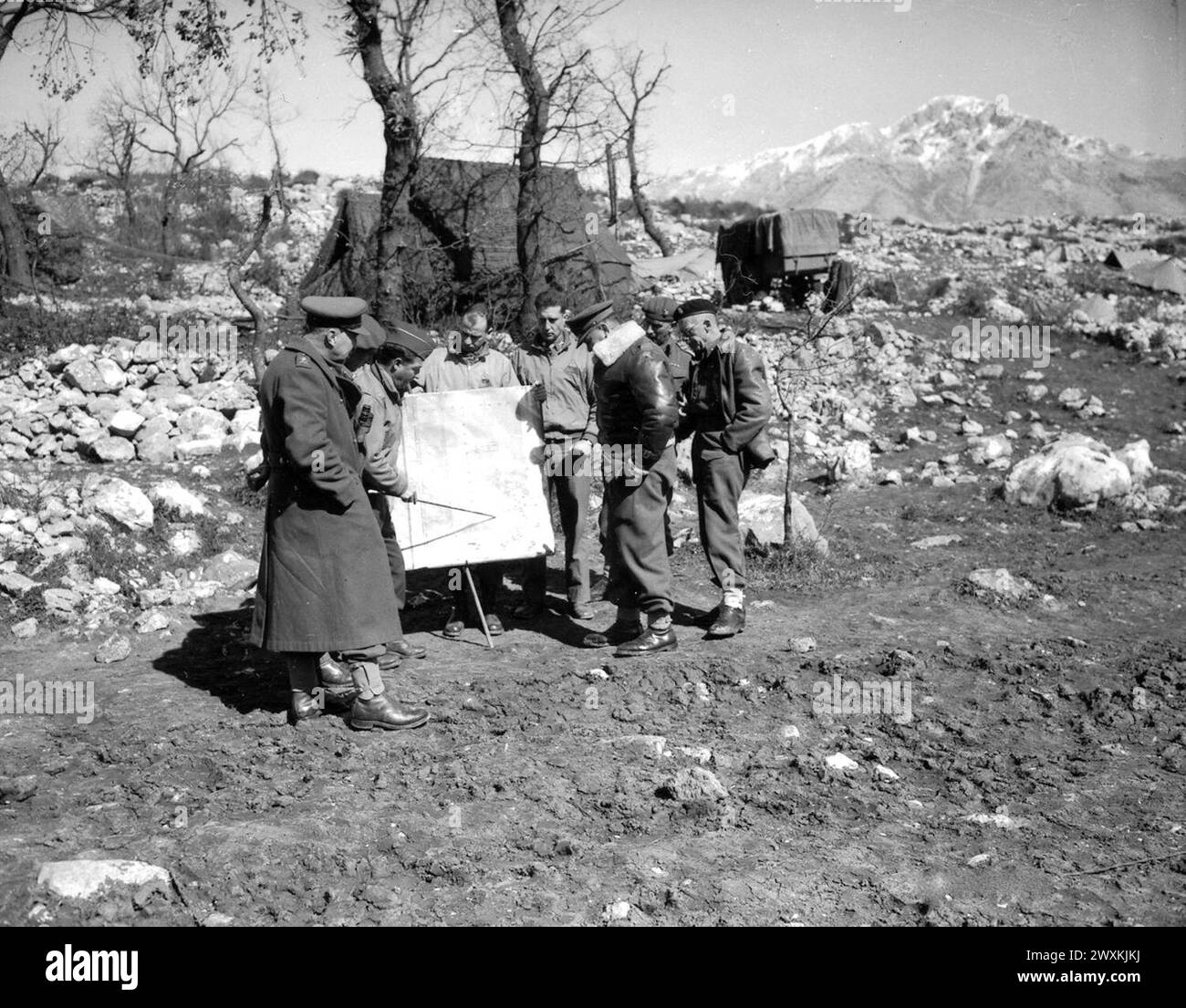 Original Caption: 'Conference of Generals concerned with the action at Cassino, Italy. Left to right: Maj. Gen. Parkinson, Brig. Gen. Ray C. Queree, Brig. Gen. Frank A. Allen, Jr., Major D.D. Klous, Lt. Col. Ben G. Crosby, Lt. Gen. Freyburg, Brig.Gen. Stephen Weir, and Brig. Gen. Keith Stuart ca. March 20, 1944 Stock Photo