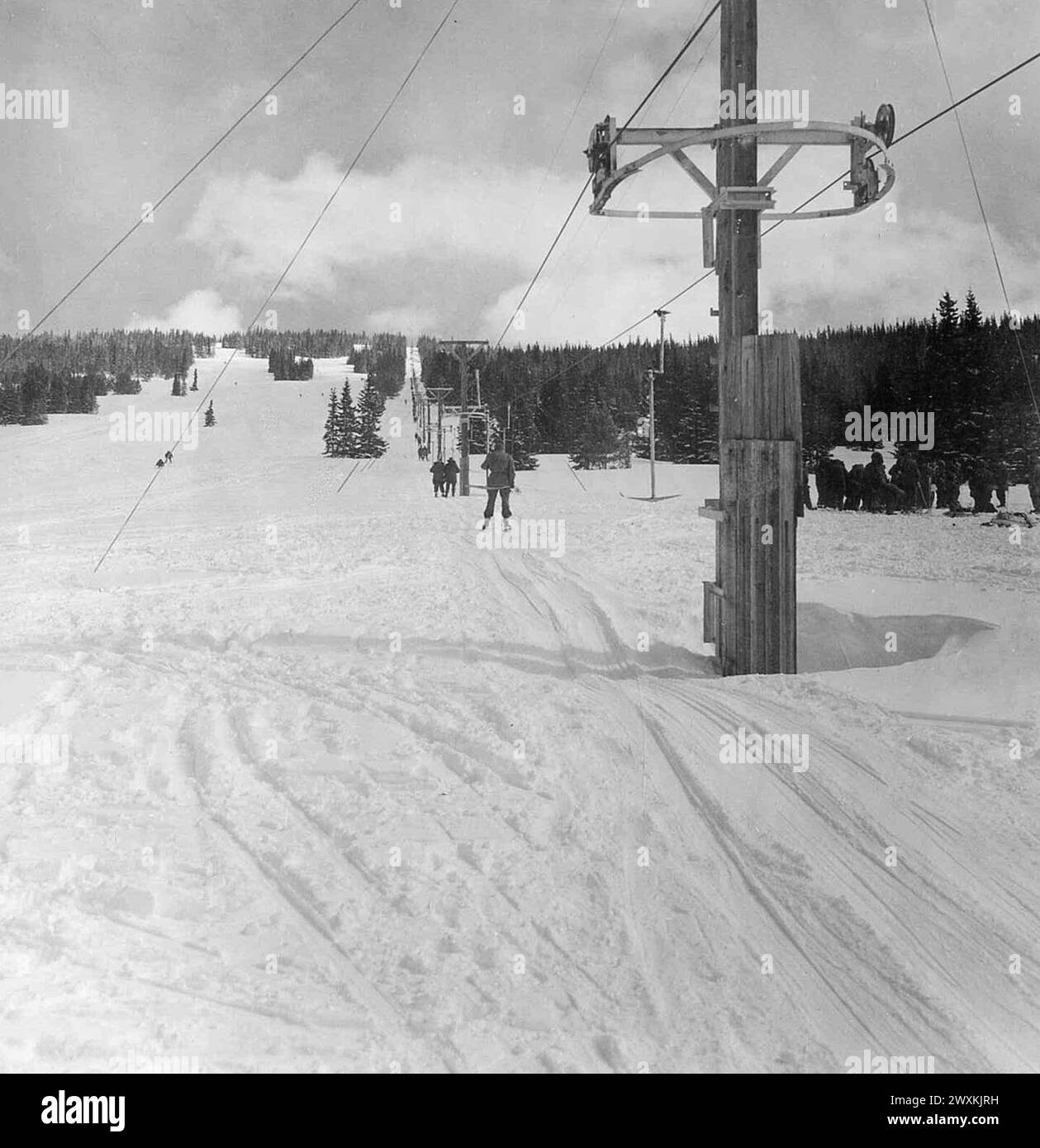 Original Caption: Men of the Mountain and Cold Weather Training Command, Camp Hale, Colorado utilizing the ski lift at the Cooper Hill ski slope located outside of Camp Hale, Colorado ca. March 1956 Stock Photo