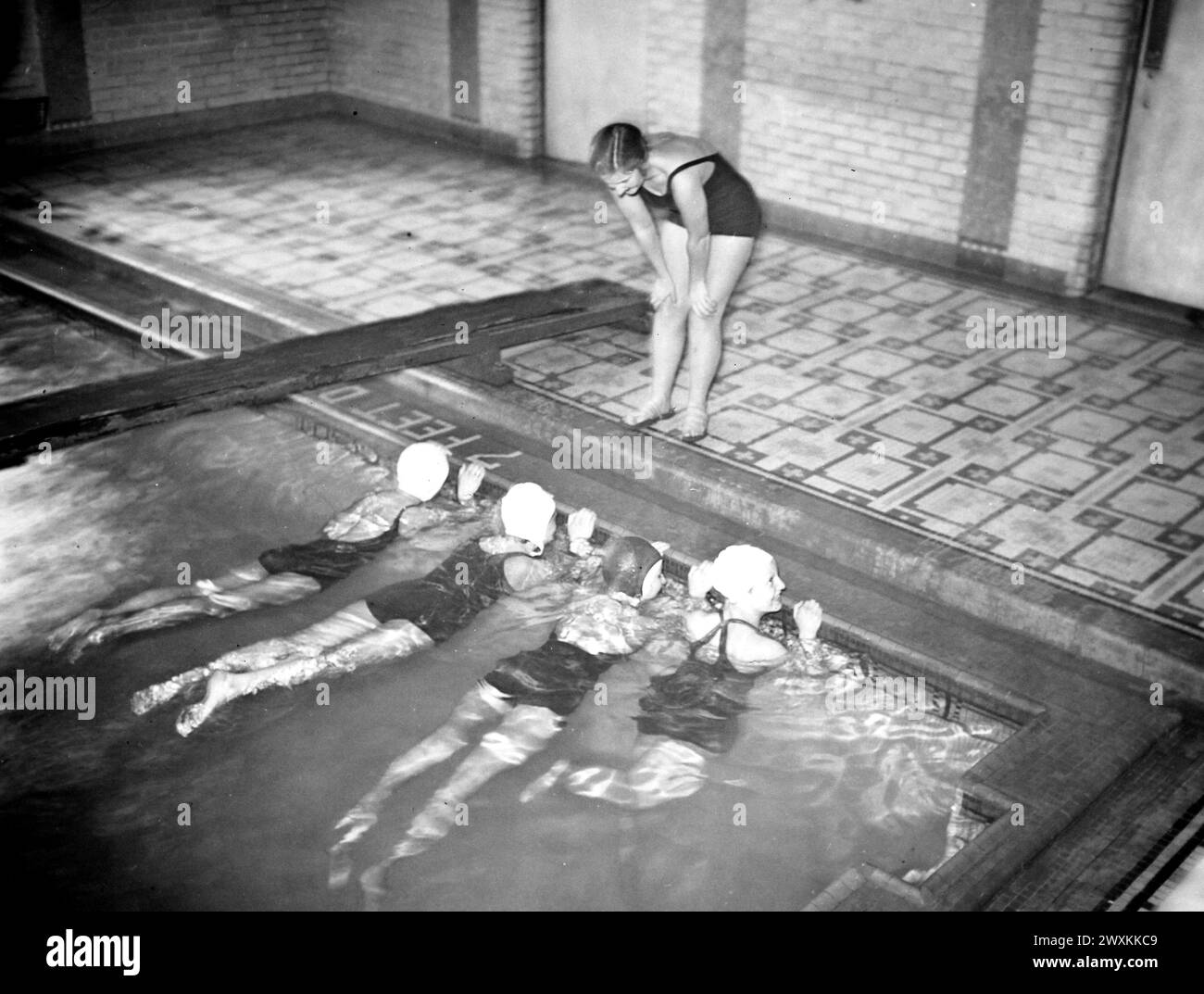 This photograph depicts a young woman affiliated with the National Youth Administration as she teaches a swimming lesson at the YWCA in Middletown, Connecticut ca. 1935-1942 Stock Photo