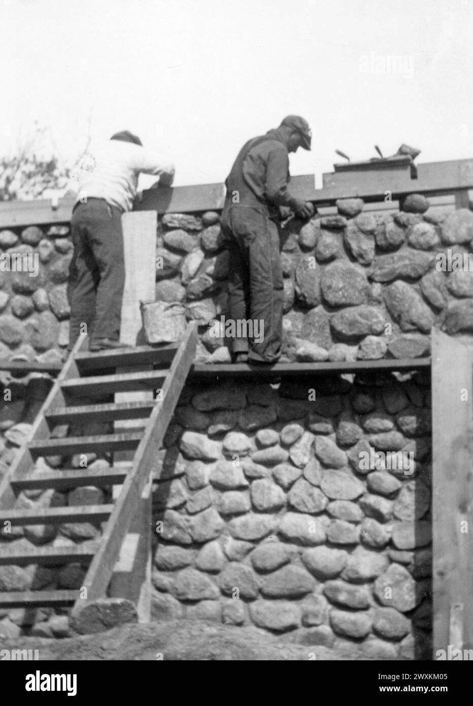 Two men working on stone house on the Sisseton-Wahpeton Oyate of the Lake Traverse Reservation, South Dakota ca. 1936-1942 Stock Photo