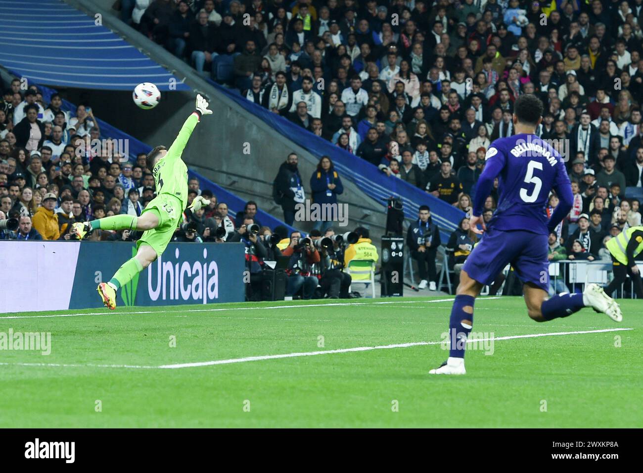 Madrid, Spain. 31st Mar, 2024. Athletic Club's goal keeper Julen Agirrezabala (L) tries to save the ball during the La Liga football match between Real Madrid and Athletic Club at Santiago Bernabeu stadium in Madrid, Spain, on March 31, 2024. Credit: Gustavo Valiente/Xinhua/Alamy Live News Stock Photo