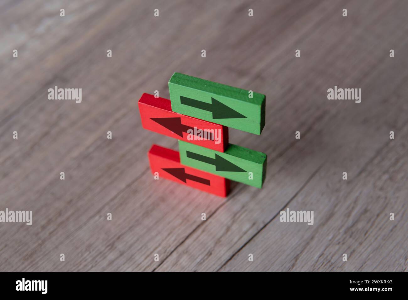 A stack of wooden blocks with arrows are pointing in opposite directions. Contradiction, different perspective concept. Stock Photo