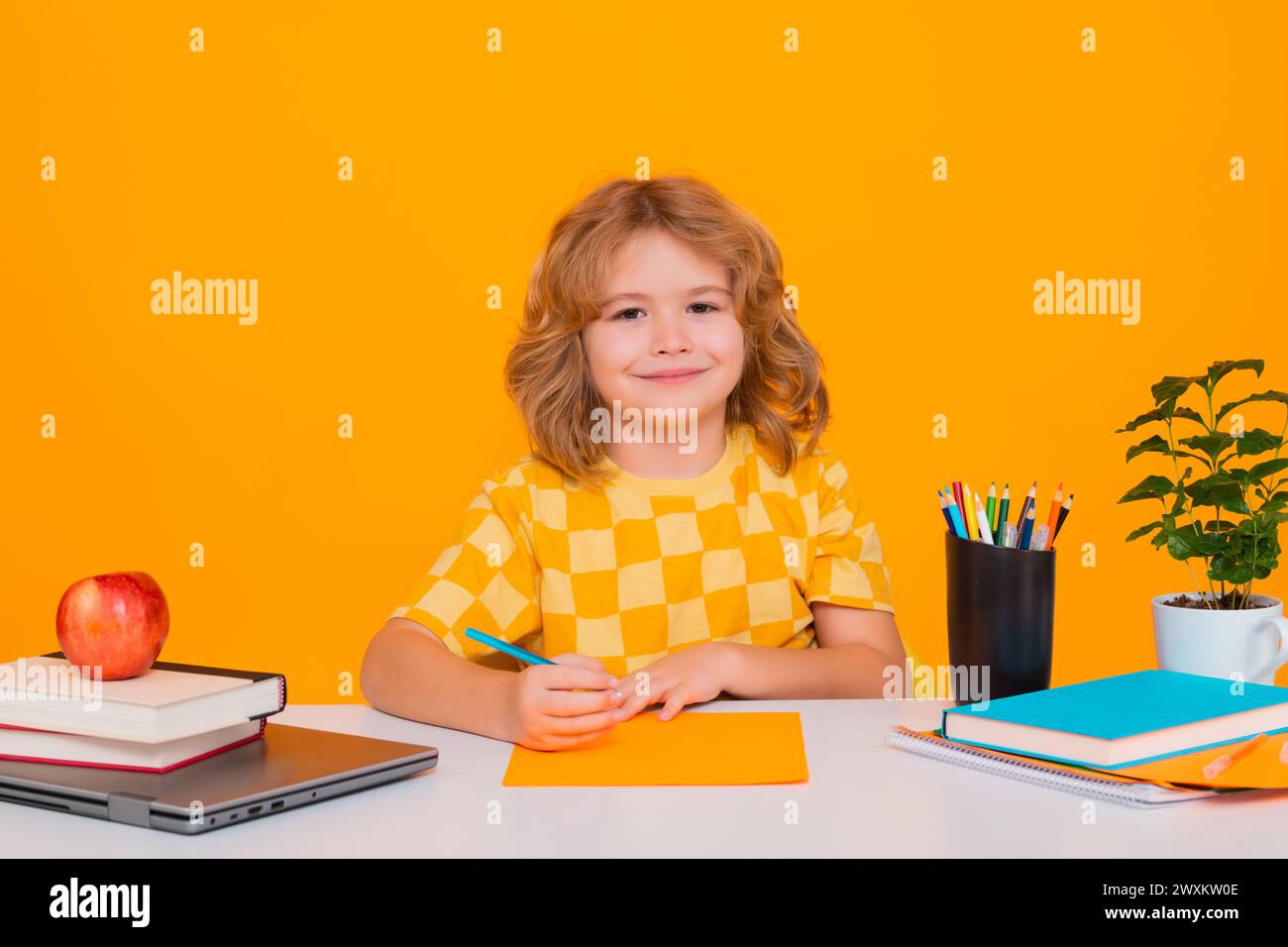Nerd pupil boy from elementary school with book isolated on yellow ...