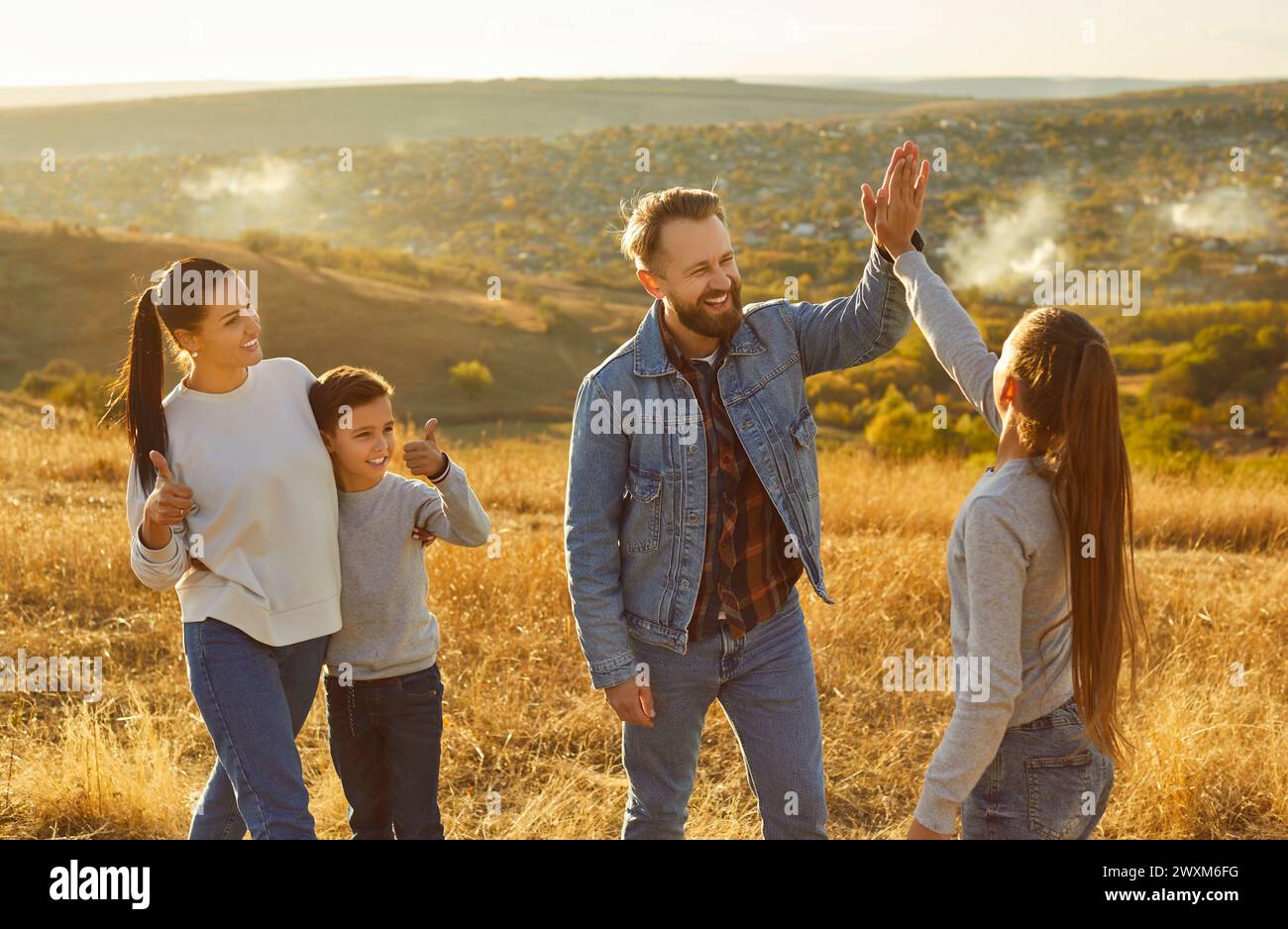 Happy friendly family nature outdoor trip, high five gesture, spending weekend holiday together Stock Photo