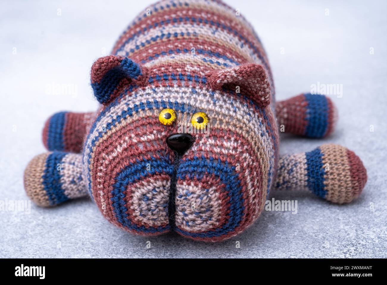 Crocheted toy cat. Melange thread. Hobby knitting. Funny animal Hook knit Stock Photo