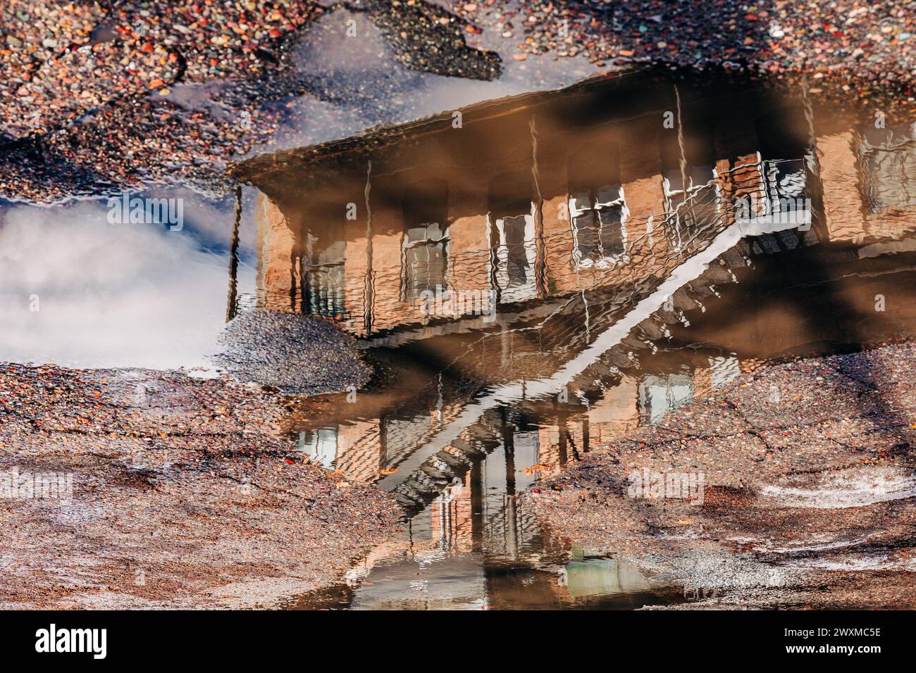 Red brick building reflected in puddle on the ground Stock Photo - Alamy