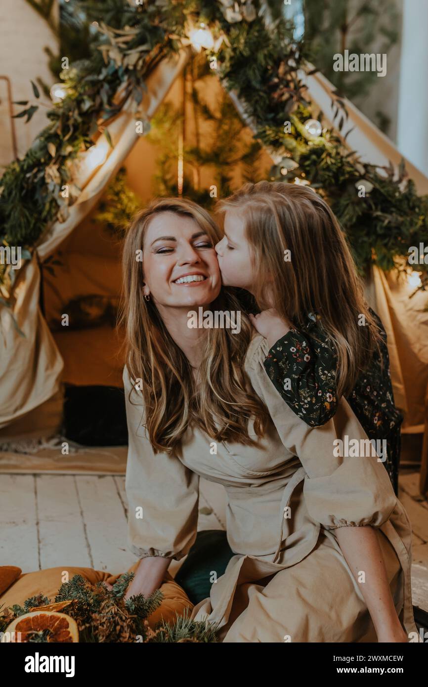A girl giving her mother a kiss on the cheek Stock Photo
