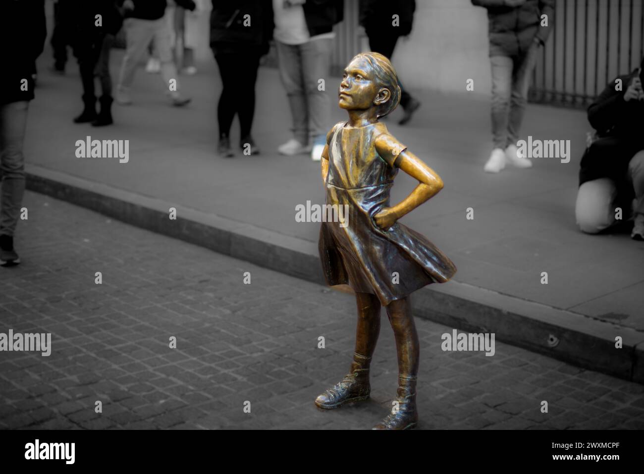 Statue of a girl in the city, placed on a sidewalk near a street Stock Photo