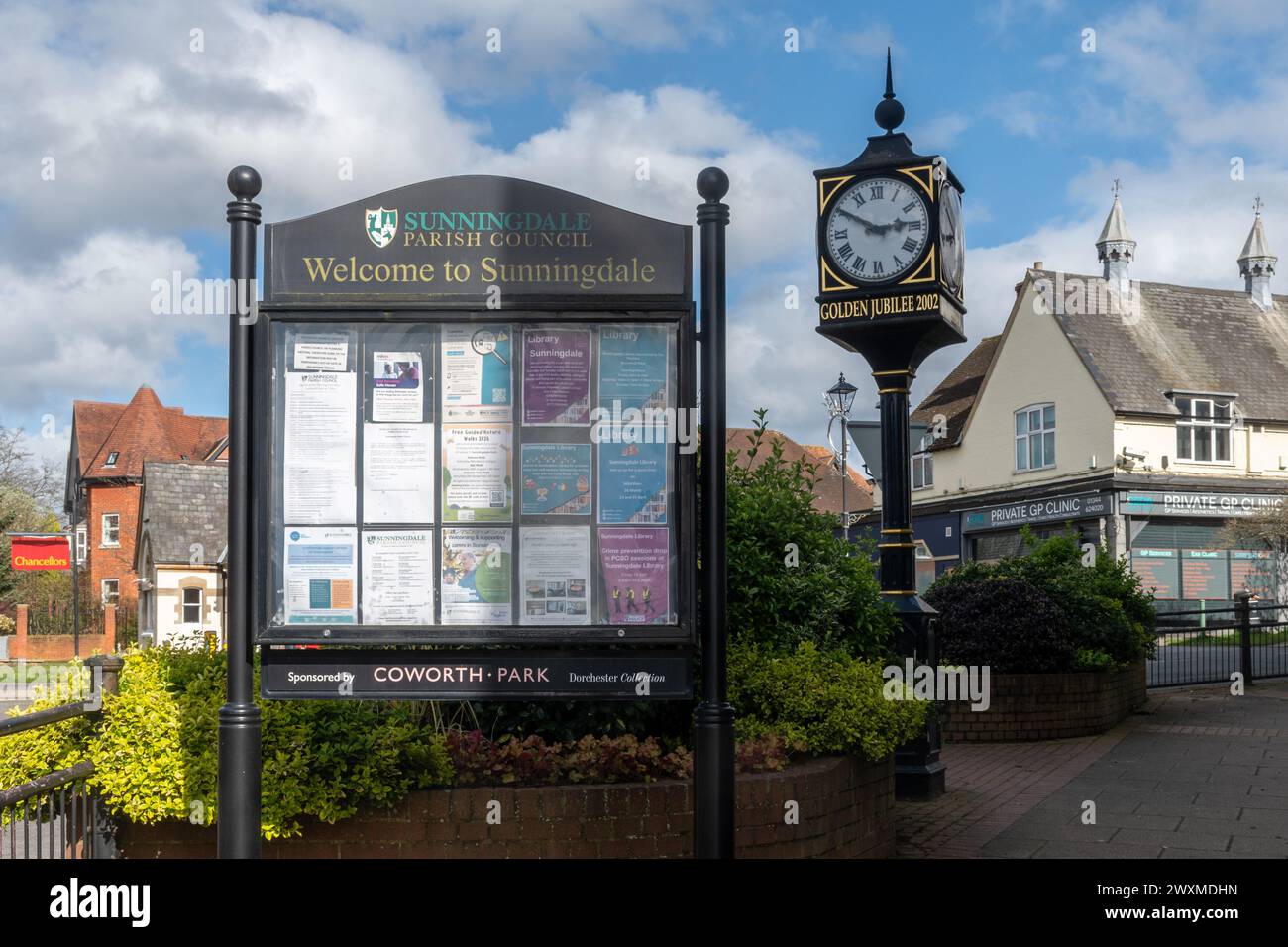 Village clock commemorating the Queen's Golden Jubilee in 2002 in Sunningdale, Berkshire, England, UK, next to the village information notice board Stock Photo