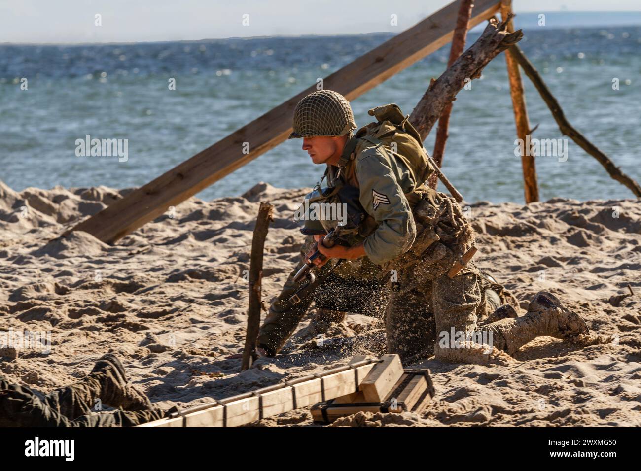 Historical reconstruction. An American infantry soldier from the World War II  fighting on the beach. Stock Photo