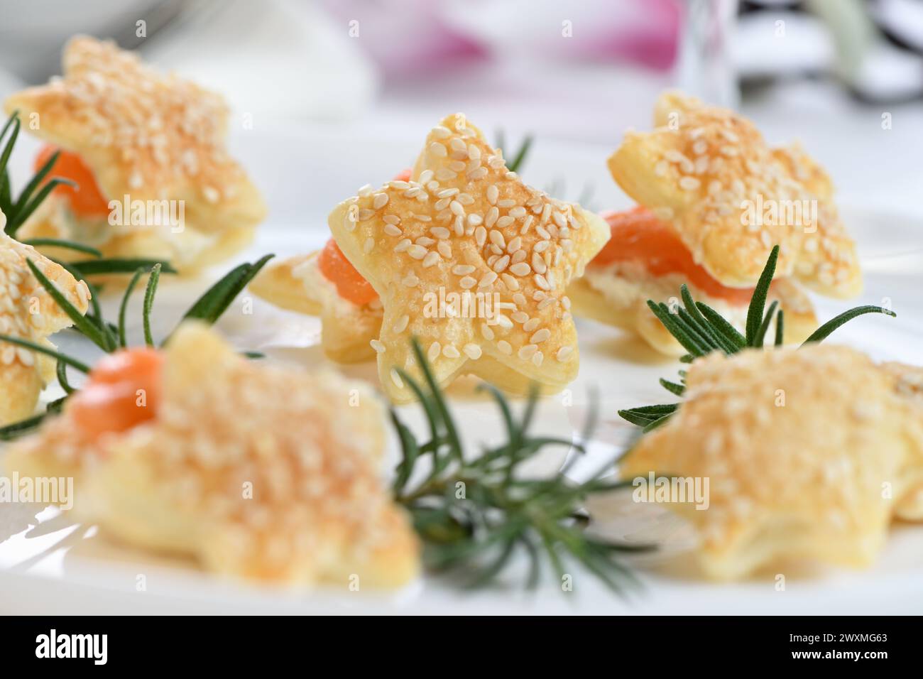 Festive appetizer of puff pastry in the shape of a star, stuffed with salmon and soft cheese. The perfect appetizer for your holiday table. Stock Photo