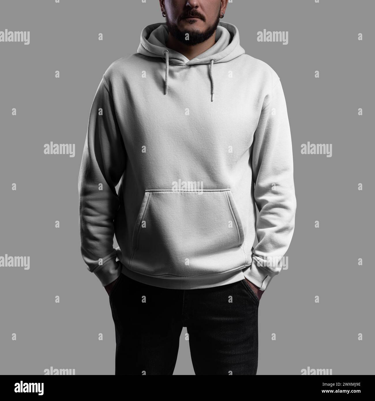 Mockup of white oversized hoodie on bearded man, sweatshirt with hood, pocket, laces, label, isolated on background with shadows, front view. Fashiona Stock Photo