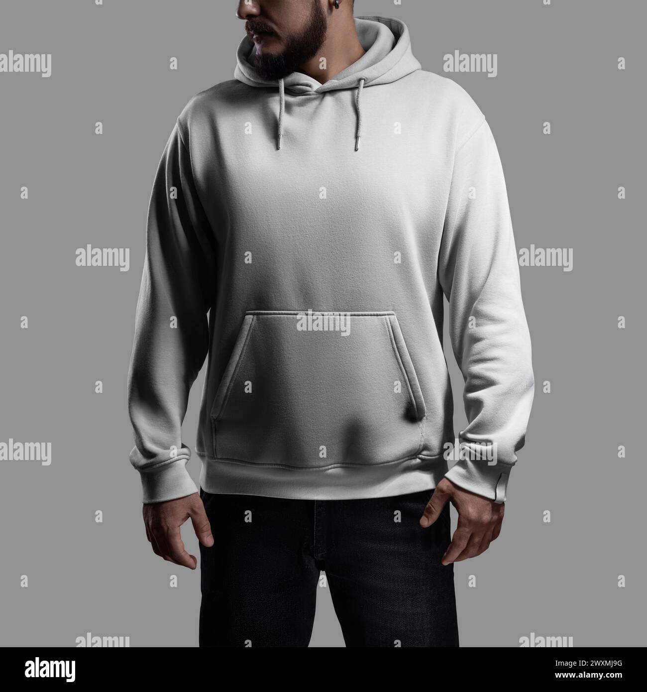 Mockup of a white oversized hoodie on a bearded man with his head turned, front view. Fashionable streetwear template for design. Sweatshirt with hood Stock Photo