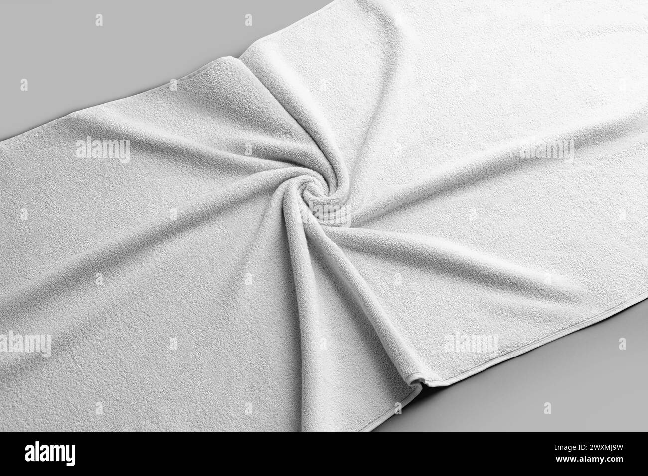 Mockup of a white terry towel, folded with wrinkles, on the background, a large bath cloth for advertising. Template of soft clothes after a shower, b Stock Photo