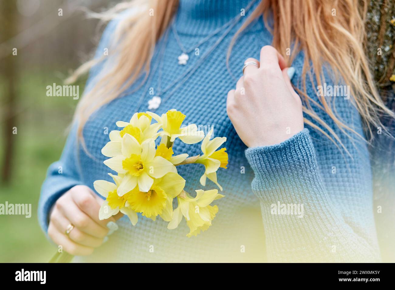 Woman holds daffodils, connected with nature, cottage core, mindfulness, self-exploration concept. Copy space. Stock Photo
