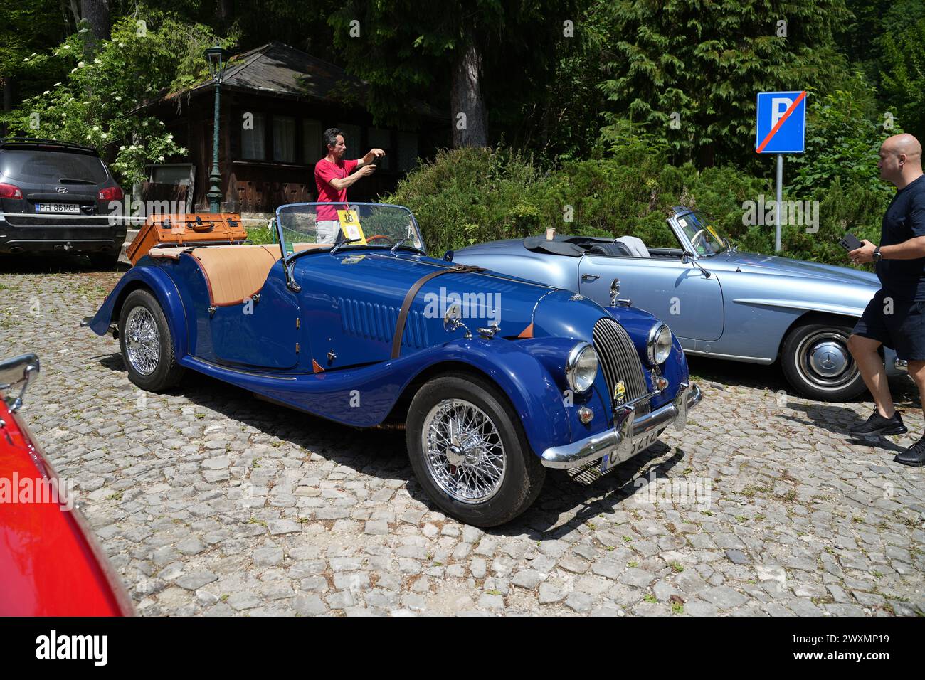 A blue 1986 Morgan Plus 4 car parked on a cobblestone road surrounded ...