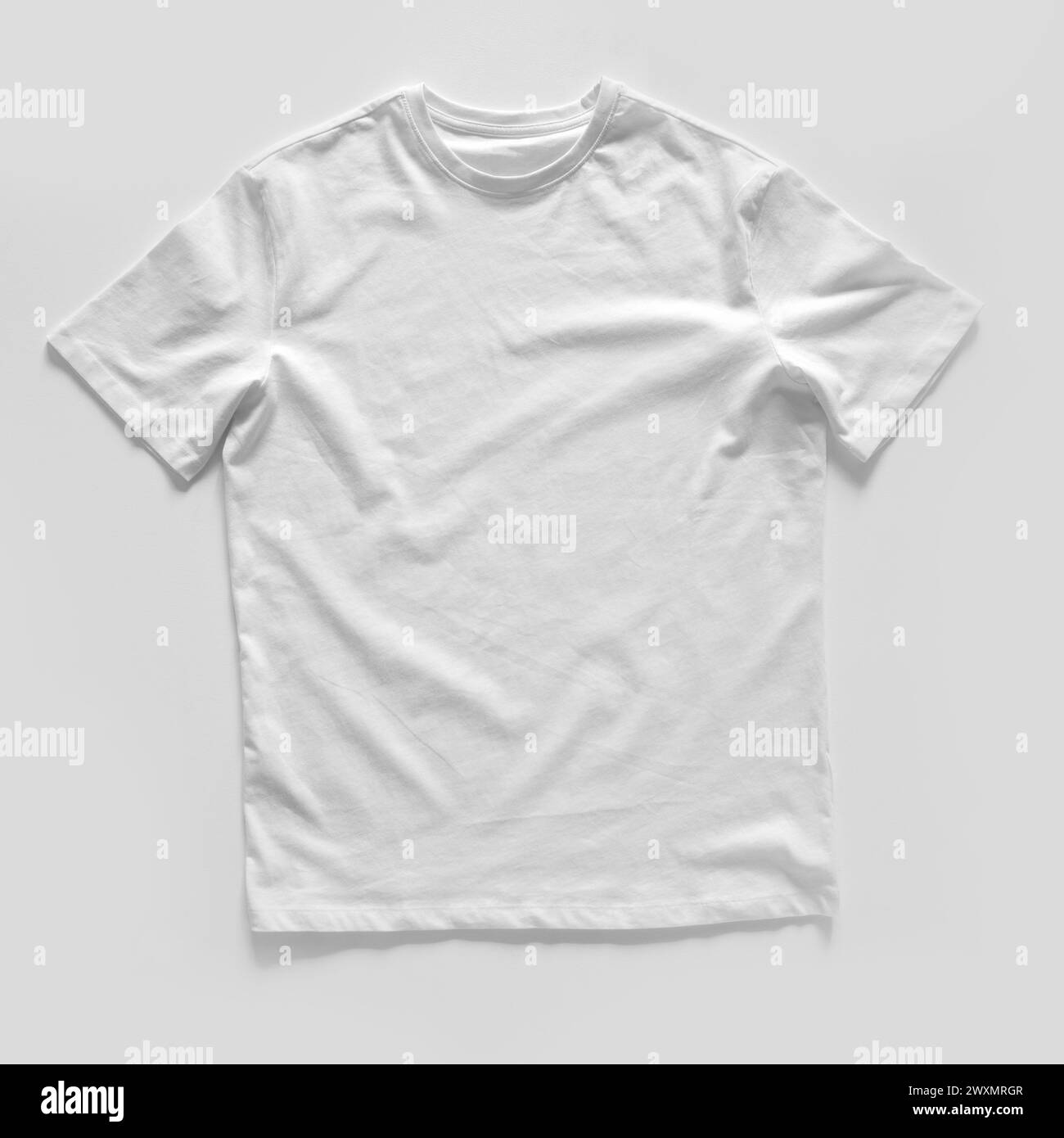 Plain White T-Shirt Displayed Flat on a Neutral Background Stock Photo