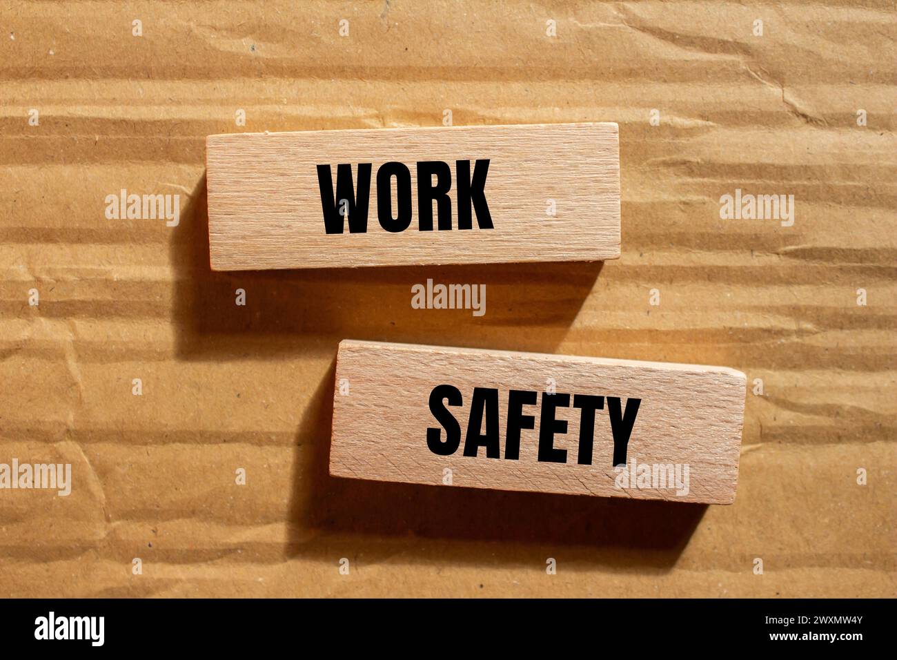 Work safety words written on wooden blocks with cardboard background. Conceptual business symbol. Copy space. Stock Photo