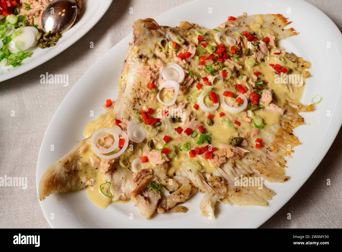 Skate Wing or Ray Wing Prepared Whole with Tuna Mayonnaise Sauce and Red Bell Pepper Stock Photo