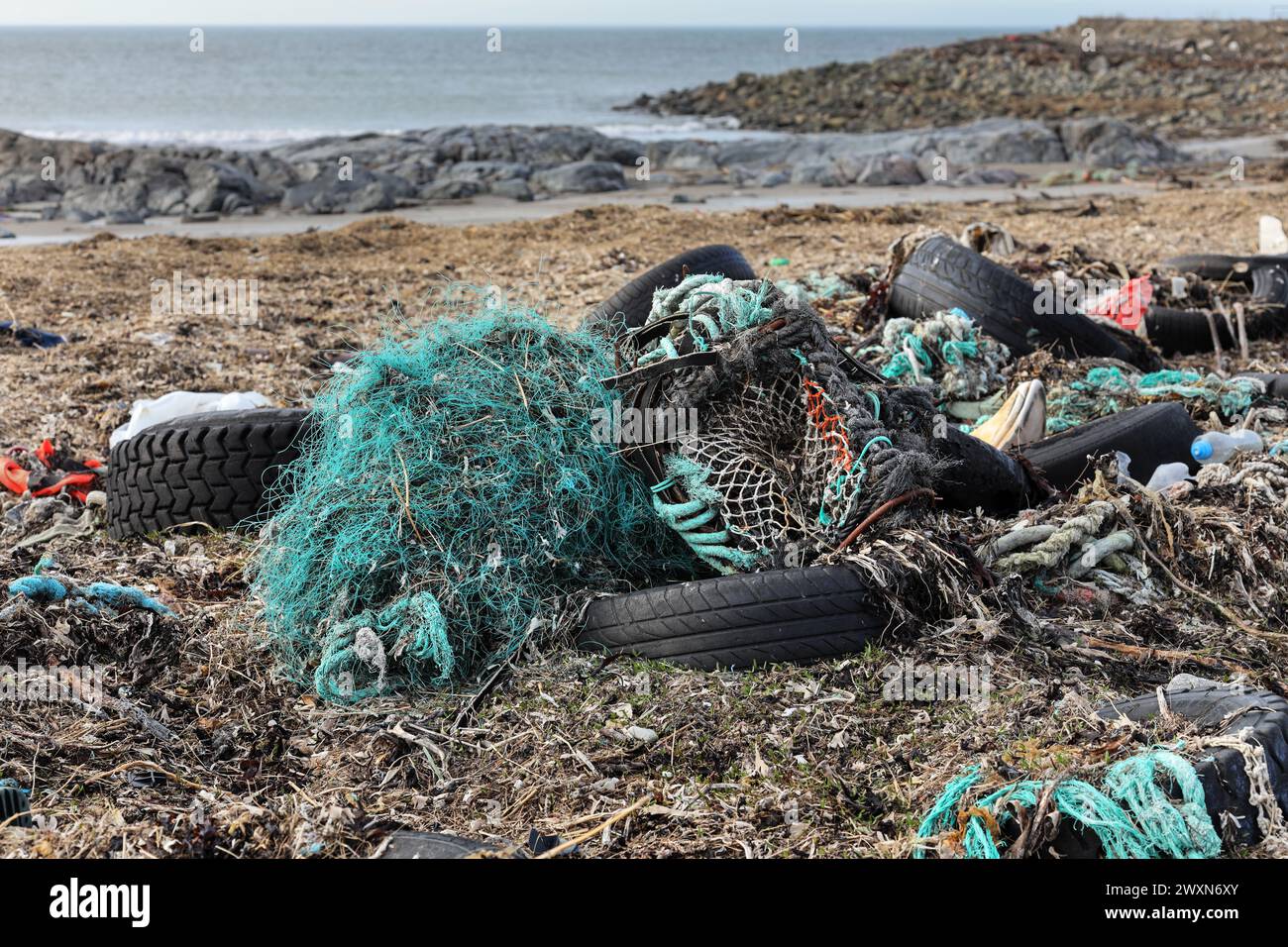 Plastics, fishing nets and other waste washed up on the coast near Fraserburgh, Aberdeenshire, Scotland, UK. A lot of this waste is produced by the fi Stock Photo