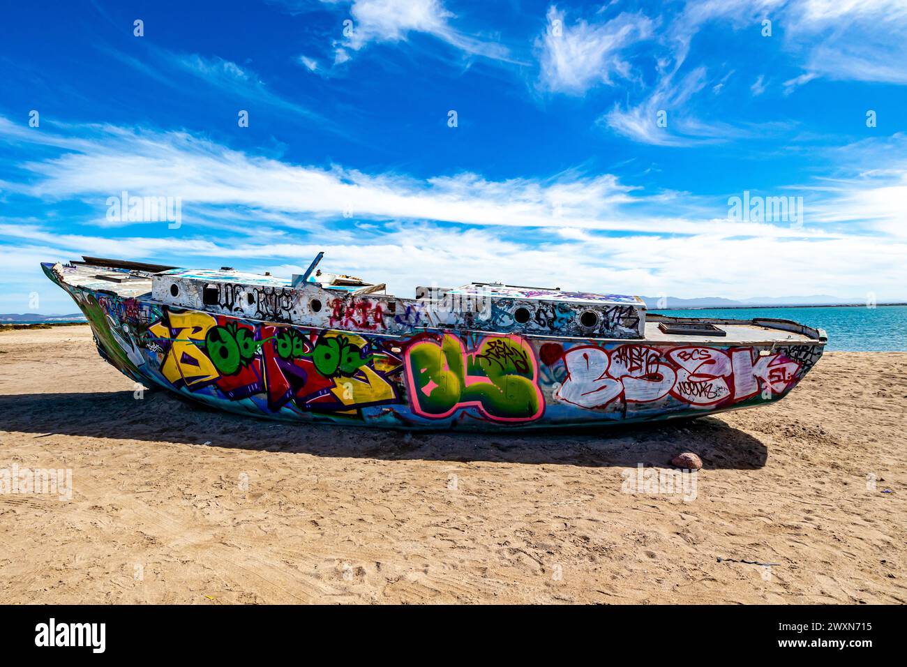 La Paz, Baja California Sur Mexico. February 9, 2023. Centenario or Comitán coastal beach with an old stranded boat painted with graffiti, sunny winte Stock Photo
