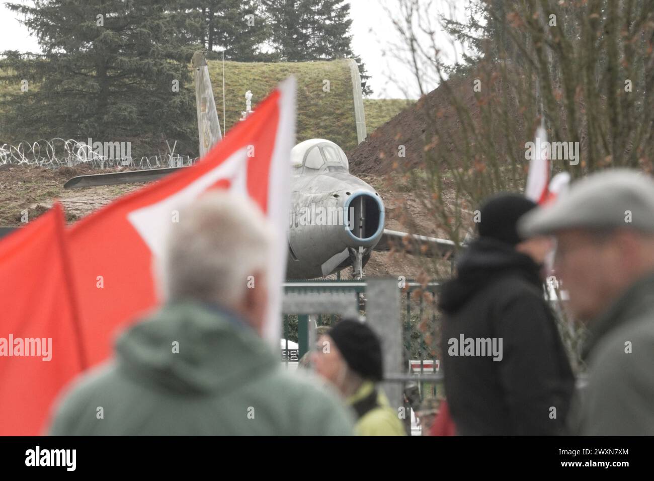 01 April 2024, Rhineland-Palatinate, Büchel: Participants in the Easter march stand with flags in front of the Büchel air base (Cochem-Zell district), where US nuclear weapons are said to be stored. Photo: Thomas Frey/dpa Stock Photo
